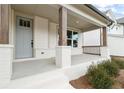 Welcoming front porch with stained wood columns and painted brick accents at 227 Wild Ginger Bnd, Woodstock, GA 30188