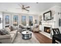 Cozy living room featuring a fireplace, large windows, hardwood floors, and comfortable seating arrangements at 233 Retreat Ln, Canton, GA 30114