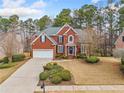 Charming two-story red brick home with a manicured front yard, green landscaping, and a driveway at 4204 Rockpoint Nw Dr, Kennesaw, GA 30152