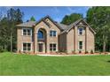 Handsome two-story brick home with a well-manicured front lawn and mature trees at 221 Lotus Ln, Covington, GA 30016