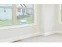 Bright bedroom features neutral walls, trim, carpet, and a view to the front yard at 211 Lotus Ln, Covington, GA 30016
