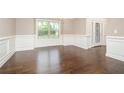 Spacious dining room with hardwood floors, wainscoting, and a large window at 211 Lotus Ln, Covington, GA 30016