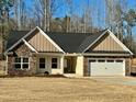 Charming single-story home with stone accents, attached two-car garage, and manicured lawn at 415 Smallwood Lane, Douglasville, GA 30134