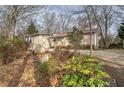 Quaint one-story house with light siding and a small set of stairs leading to the front door, surrounded by greenery at 58 Knox Rd, Powder Springs, GA 30127