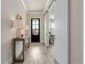 Stylish entryway with wood floors, modern lighting, and a decorative sliding barn door feature at 6180 Bellmoore Park Ln, Duluth, GA 30097