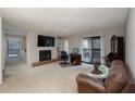 Bright living room with a cozy fireplace, TV and sliding glass doors to a deck offering natural light and air at 1804 Cumberland Se Ct, Smyrna, GA 30080
