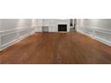 Spacious living room featuring detailed wainscoting, hardwood floors, a fireplace, and custom built-in shelving at 156 Page Pl, Canton, GA 30114