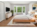 Serene main bedroom boasts a bay window, closet, light wood floors, and modern furnishings at 156 Page Pl, Canton, GA 30114