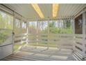 Enclosed back porch featuring white wood railings and a serene view of the surrounding greenery at 4063 Elmscourt Dr, Stone Mountain, GA 30083