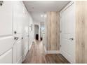 Hallway with light wood floors and wood accent wall, leading towards a bright room with a view at 200 River Vista Dr # 502, Atlanta, GA 30339