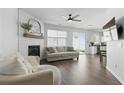 Bright and airy living room with a cozy fireplace, modern ceiling fan, and sliding glass door to the patio at 129 Swanee Ln, Woodstock, GA 30188