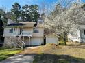 Exterior view of the split level home with an accessory garage and flowering tree at 3170 Ashly Brooke Dr, Snellville, GA 30078