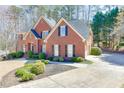 Attractive brick home showcasing an attached garage, a well-maintained driveway, and lush landscaping enhancing its curb appeal at 4330 Landover Nw Way, Suwanee, GA 30024