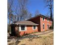 Side view of the two-story brick home showcasing attached garage and manicured landscape at 4625 Orkney Sw Ln, Atlanta, GA 30331