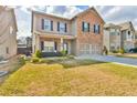 Inviting two-story home featuring a brick facade and a well-maintained lawn with beautiful landscaping at 2461 Melton Common Dr, Dacula, GA 30019
