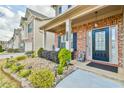 Close-up of a front porch showcasing a brick facade, decorative lighting, and mature landscaping at 2461 Melton Common Dr, Dacula, GA 30019
