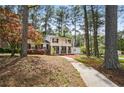 Well-maintained two-story home with a sidewalk leading to a yellow front door, surrounded by mature trees at 3973 Elmscourt Dr, Stone Mountain, GA 30083