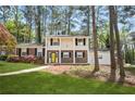 Well-maintained two-story home with a sidewalk leading to a yellow front door, surrounded by mature trees at 3973 Elmscourt Dr, Stone Mountain, GA 30083