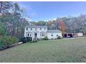 Traditional two-story home featuring a manicured lawn and mature trees at 4424 Lower Fayetteville Rd, Sharpsburg, GA 30277