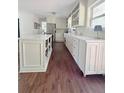 Spacious kitchen with a center island, white cabinetry, and wood flooring at 4424 Lower Fayetteville Rd, Sharpsburg, GA 30277