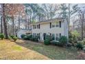 A quaint two-story house with gray siding, dark shutters, an attached garage, and a sloped front yard at 4641 Waterford Ct, Atlanta, GA 30338