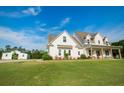 Beautiful two-story home boasts a covered porch, complemented by a sprawling green lawn and outbuilding at 774 Forrester Cemetery Rd, Covington, GA 30014