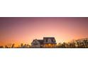 Charming two-story home bathed in the warm glow of a sunset against a stunning twilight sky at 774 Forrester Cemetery Rd, Covington, GA 30014