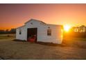 Rustic outbuilding featuring a convenient open bay, set against a backdrop of a vibrant sunset at 774 Forrester Cemetery Rd, Covington, GA 30014