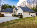 A view of the back of a charming single-story home with a pristine lawn and an attached two-car garage at 25 Cherokee Hills Dr, Rydal, GA 30171
