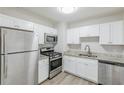 Well-lit kitchen equipped with stainless steel appliances, white cabinets, and modern countertops at 3164 Robin Rd, Decatur, GA 30032