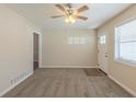 Inviting living room features plush carpet, ceiling fan, natural light, and door to kitchen, creating a cozy space at 3465 Tulip Dr, Decatur, GA 30032