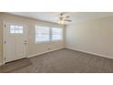 Bright living room with new carpet, white trim, a ceiling fan, and a large window providing plenty of natural light at 3465 Tulip Dr, Decatur, GA 30032