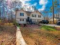 Two-story home featuring a well-manicured front yard with mature trees, a driveway and a two-car garage at 45 Side Trail, Covington, GA 30016
