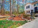 Landscaped front yard featuring a seating area with decorative stones, mulch and mature trees surrounding the house at 45 Side Trail, Covington, GA 30016