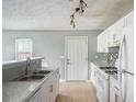 Functional kitchen with white cabinets, modern appliances, granite countertops, and tile flooring at 72 Polar Rock Rd, Atlanta, GA 30315