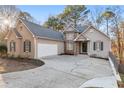 Charming stucco home with stone accents, driveway, and a two-car garage at 7065 Walnut Mill Ct, Cumming, GA 30040