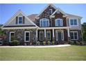 Beautiful two-story home featuring stone and brick accents, paired with well-maintained landscaping and a welcoming front yard at 838 Natchez Valley Trce, Grayson, GA 30017