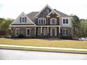 Beautiful two-story home with a mix of stone and brick facade, shutters, and a well-kept lawn at 838 Natchez Valley Trce, Grayson, GA 30017