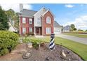 Lovely two-story brick home with manicured lawn, charming lighthouse statue and attached garage at 2000 Spicers Ln, Woodstock, GA 30189