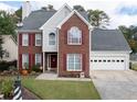 Beautiful two-story brick home with attached garage, red shutters and manicured landscaping at 2000 Spicers Ln, Woodstock, GA 30189