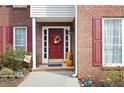 Inviting front door with brick surround, fall wreath and stacked pumpkins for seasonal appeal at 2000 Spicers Ln, Woodstock, GA 30189