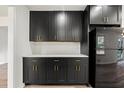 Features modern cabinetry, contrasting gold hardware, a white backsplash, and stainless-steel appliances at 1025 S Indian Creek Dr, Stone Mountain, GA 30083