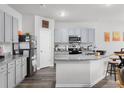 Modern kitchen with stainless steel appliances, granite countertops, and stylish grey cabinetry at 9122 Golfview Cir, Covington, GA 30014