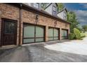 Three-car garage featuring unique glass panel doors, plus a side entrance at 6029 Shadburn Ferry Rd, Buford, GA 30518