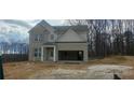 Two-story home featuring brick and siding, with an attached two-car garage on an unfinished lot at 6015 Spring Way, Stonecrest, GA 30038