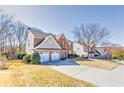 Two-story brick home boasts a well-maintained lawn and convenient two-car garage at 1510 Ridgemill Ter, Dacula, GA 30019