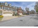 A welcoming neighborhood streetscape with charming townhomes and manicured lawns at 7467 Portbury Park Ln, Suwanee, GA 30024