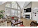 Inviting living room with vaulted ceilings, stone fireplace, and lots of natural light at 7467 Portbury Park Ln, Suwanee, GA 30024