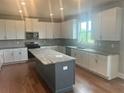 Spacious kitchen with white cabinets, gray island, stainless appliances and granite countertops at 320 Willow Cv, Canton, GA 30114