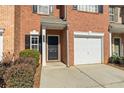 Charming townhouse entrance with a black front door, single car garage, and neatly trimmed shrubs at 3815 Pleasant Oaks Dr, Lawrenceville, GA 30044